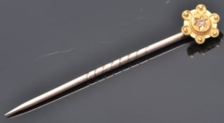 A 9ct gold toped tie pin having wire work and ball finial decoration set with a single diamond chip.