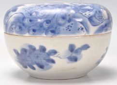 A 19th Century Chinese blue and white lidded pot being hand painted with peacocks beneath a