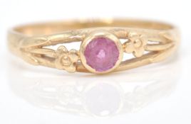 A hallmarked 9ct gold and ruby ring. The central mixed cut ruby in a pierced flower setting.