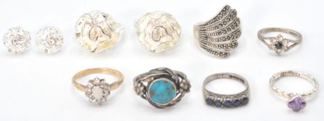 A collection of silver dress rings to include 5 stone ring, flower head ring. solitaire ring, rose