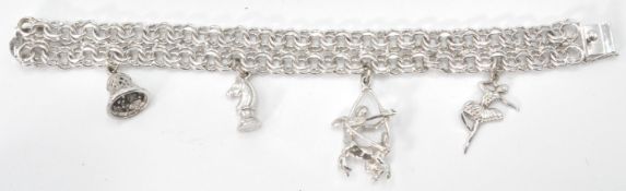 A sterling silver dual link charm bracelet having box clasp. Adorned with four charms to include a
