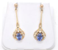 A pair of yellow gold, cornflower blue sapphire and diamond drop earrings.