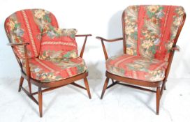 Two vintage retro 20th Century Ercol dark elm stick back open arm lounge chairs one having a round