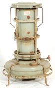 A vintage retro 20th Century metal paraffin heater by Aladdin of cylindrical form raised on a