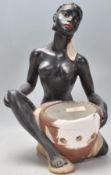 A vintage early 20th century Art Deco chalk 1920s ware figurine in the form of a seated African