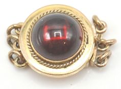 An antique 9ct gold garnet set clasp. The clasp set with a round garnet cabochon surrounded by