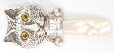 A stamped sterling silver childs rattle in the form of a Louis Wain style cat with yellow glass eyes