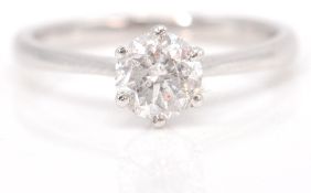 An 18 ct white gold single stone diamond ring. The cushion-shaped diamond, claw-set to a polished