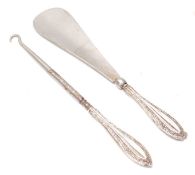 A pair of early 20th Century silver handled dressing table items to include a button hook and a shoe