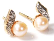 A pair of 20th Century pearl and diamond earrings set on gold posts. Comes boxed. Weighs 1g,