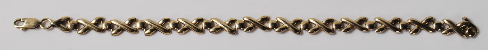 A stamped 375 9ct gold bracelet having cross over design links and a lobster clasp. Weight 5.1g.