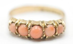 A 19th Century Victorian 9ct gold ring set with five angel skin coral cabochons in prong settings.