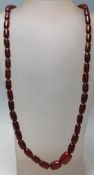 A vintage 20th Century cherry bakelite necklace having cylindrical red beads with a spring ring