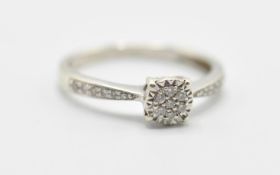 A 9ct white gold ladies dress ring having a diamond cluster in a cathedral setting and further