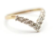 A hallmarked 9ct gold wishbone ring being illusion set with round cut white accent stones.