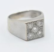 An 18ct white gold and diamond ring having a square head set with five brilliant cut diamonds on a