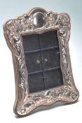 A antique white metal silver photo frame having floral decoration to the margin. Measures: 20cm