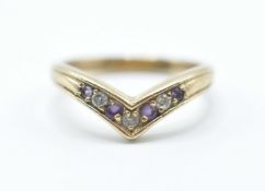 A stamped 375 9ct gold wishbone ring being set with alternate white and purple stones. Weight 3.
