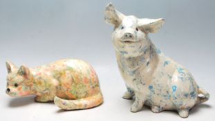 Two 20th Century ceramic large figurines in the form of a pig and a crouching cat each having