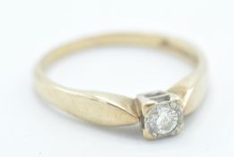 A stamped 375 9ct gold ring being illusion set with a round cut white stone in a square setting with
