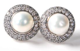 A pair of stamped .925 ladies dress earrings having a pearl set within a halo of CZ stones. Weighs