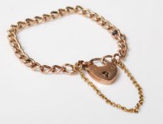 A stamped 9ct gold antique early 20th Century childs curb link bracelet having a heart padlock and