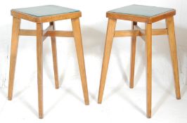 A pair of vintage retro 20th Century industrial beech wood framed stools having green faux leather
