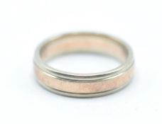 A hallmarked 9ct gold two tone band ring having a central band of rose gold within white gold