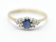 A hallmarked 9ct gold ring having a central oval cut blue stone flanked by six white accent