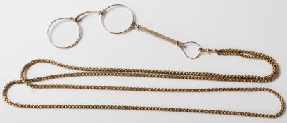 A pair of early 20th Century yellow metal lorgnettes / spectacles opera glasses having an extendable