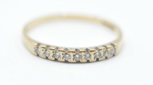 A 9ct gold ring set with nine round cut diamonds in channel settings. Assay marked for London.