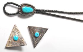 A silver white metal and leather Native American Navajo made bolo tie having a large turquoise