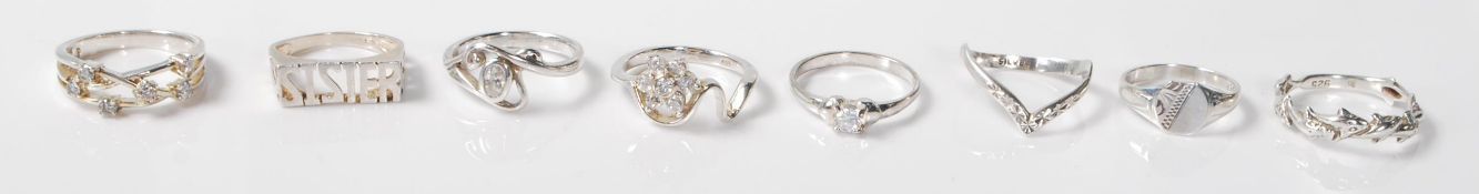 A collection of 8 silver rings to include a silver ring with a repeating dolphin motif, a silver