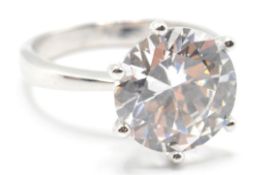 A stamped .925 silver ladies dress ring having a central large round cut CZ set within a prong
