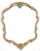 A good mid 20th century retro  gilt frame rococo mirror in a shape of a shield having Rococo style