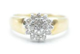 A stamped 18ct gold ring having a tapering band with a cluster of round cut diamonds. Band marked