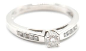 A white gold ladies dress ring having a central diamond of 20 points together with further accent