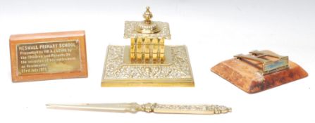 A good collection of brass desk tidy items to include a brass inkwell, brass letter opening, brass