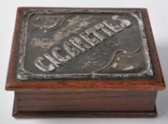 An Arts and Crafts early 20th Century wooden cigarette box / case having a hinged lid with a
