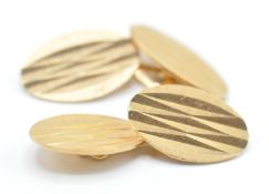 A pair of 20th Century 18ct gold gentleman's cufflinks having oval heads with engraved faceted