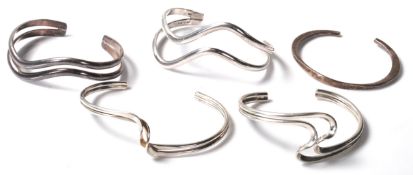 A group of five stamped 925 silver bangles four split design wave shaped bangle and one of plain