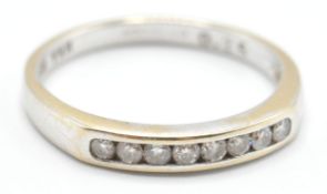 A hallmarked 18ct white gold ring being channel set with eight round cut diamonds. Hallmarked