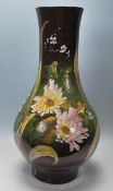 A large 20th Century baluster vase being having painted with floral sprays on a dark green and black