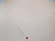 A 18ct white gold pendant necklace, the pendant having a central ruby with a halo of accent diamonds