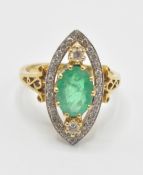 A hallmarked 18ct gold emerald and diamond ring. The ring having a pierced marquise shaped head