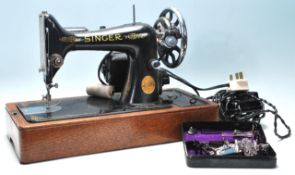 A vintage mid 20th Century Singer electric tabletop sewing machine having black body with gold
