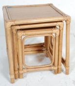 A retro vintage 20th Century bamboo / cane nest of graduating tables. Raised on bamboo supports