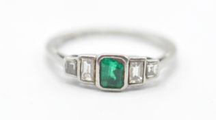 A platinum, emerald and diamonds ring having a central rectangular cut emerald flanked by four
