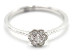 An 18ct white gold ladies dress ring in the shape of a flower having a central diamond set within