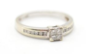 A hallmarked 9ct gold ring set with four square cut diamonds to the head with further accent